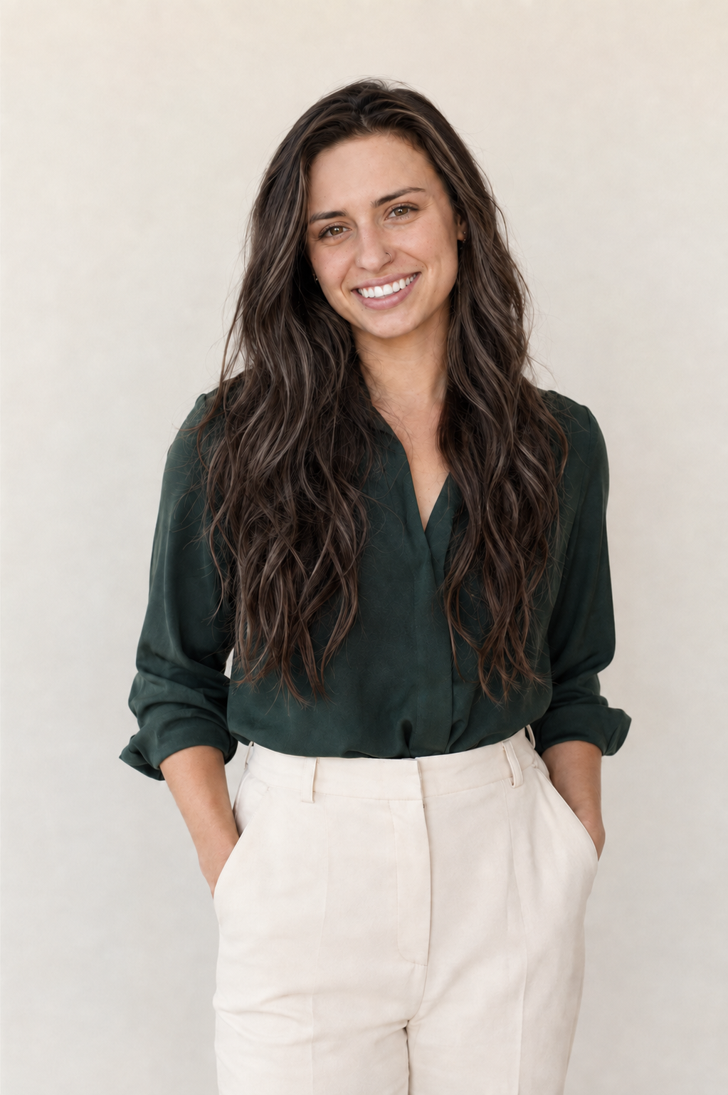 Portrait of Ashley Vitek smiling, wearing a forest-green blouse with her hands in her pockets